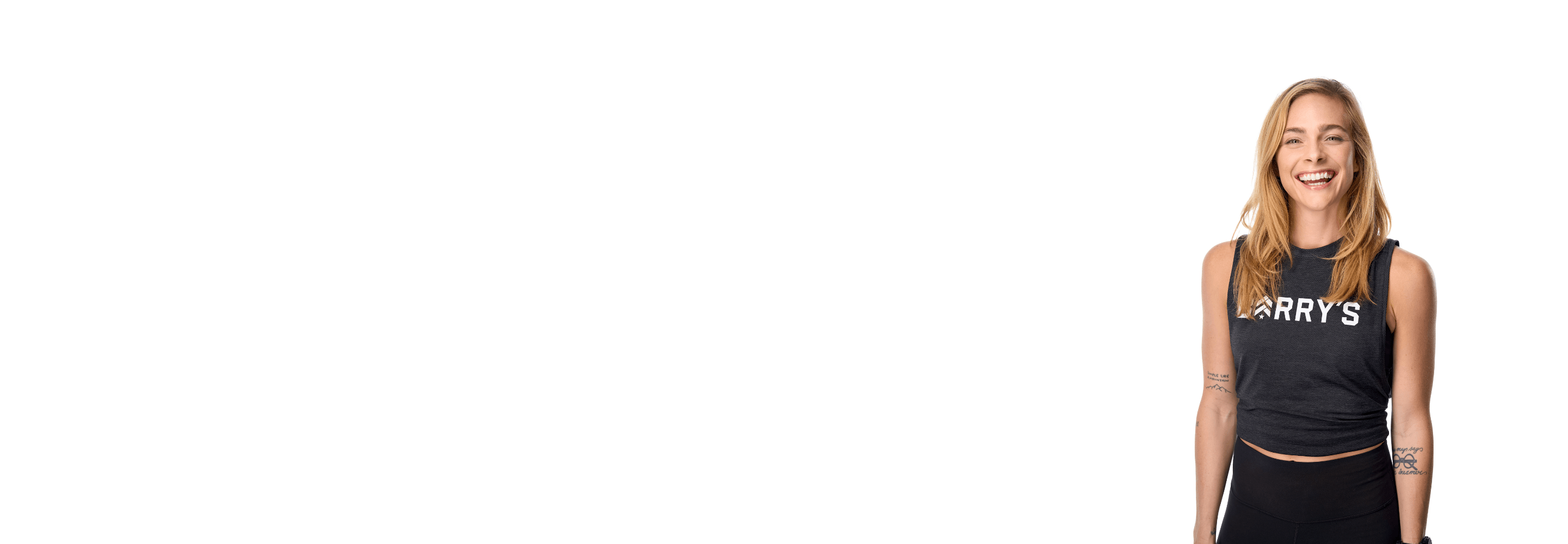 Barry’s instructor wearing a black top standing confidently smiling against a white background