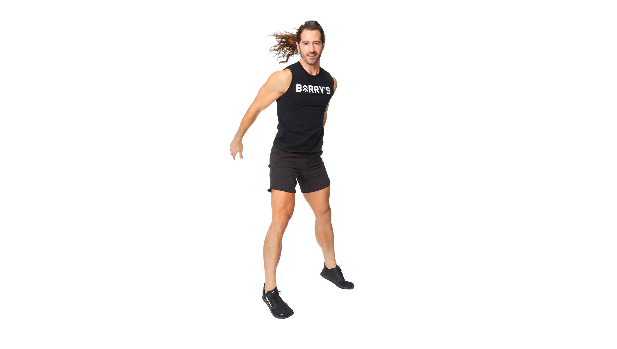 Barry's instructor in a jump position wearing a black top against a white background.
