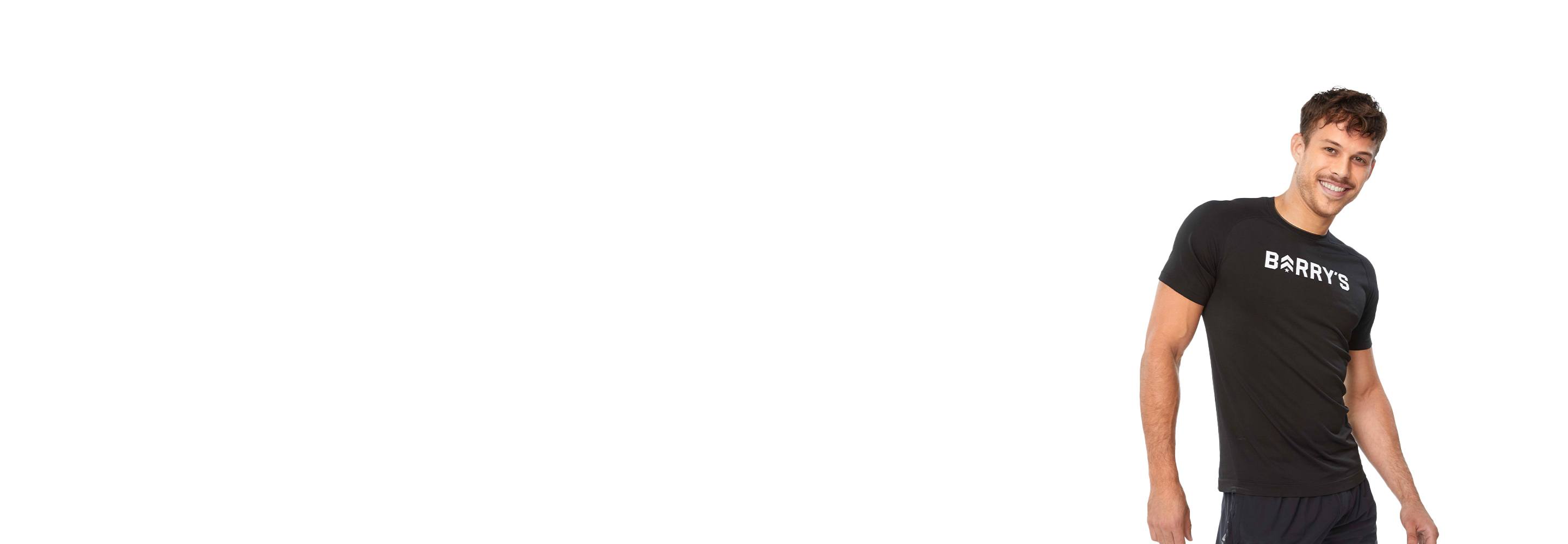 L'instructeur de Barry se tient debout avec confiance, portant un haut noir sur fond blanc, prêt pour le prochain défi d'entraînement.