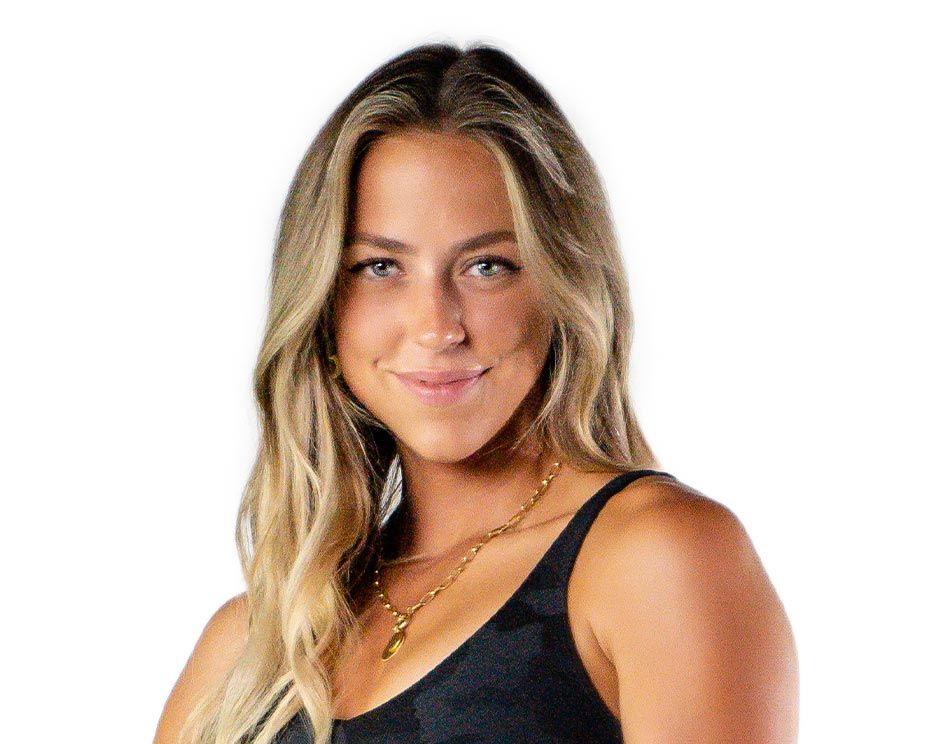 Barry’s instructor wearing a black top standing confidently smiling against a white background