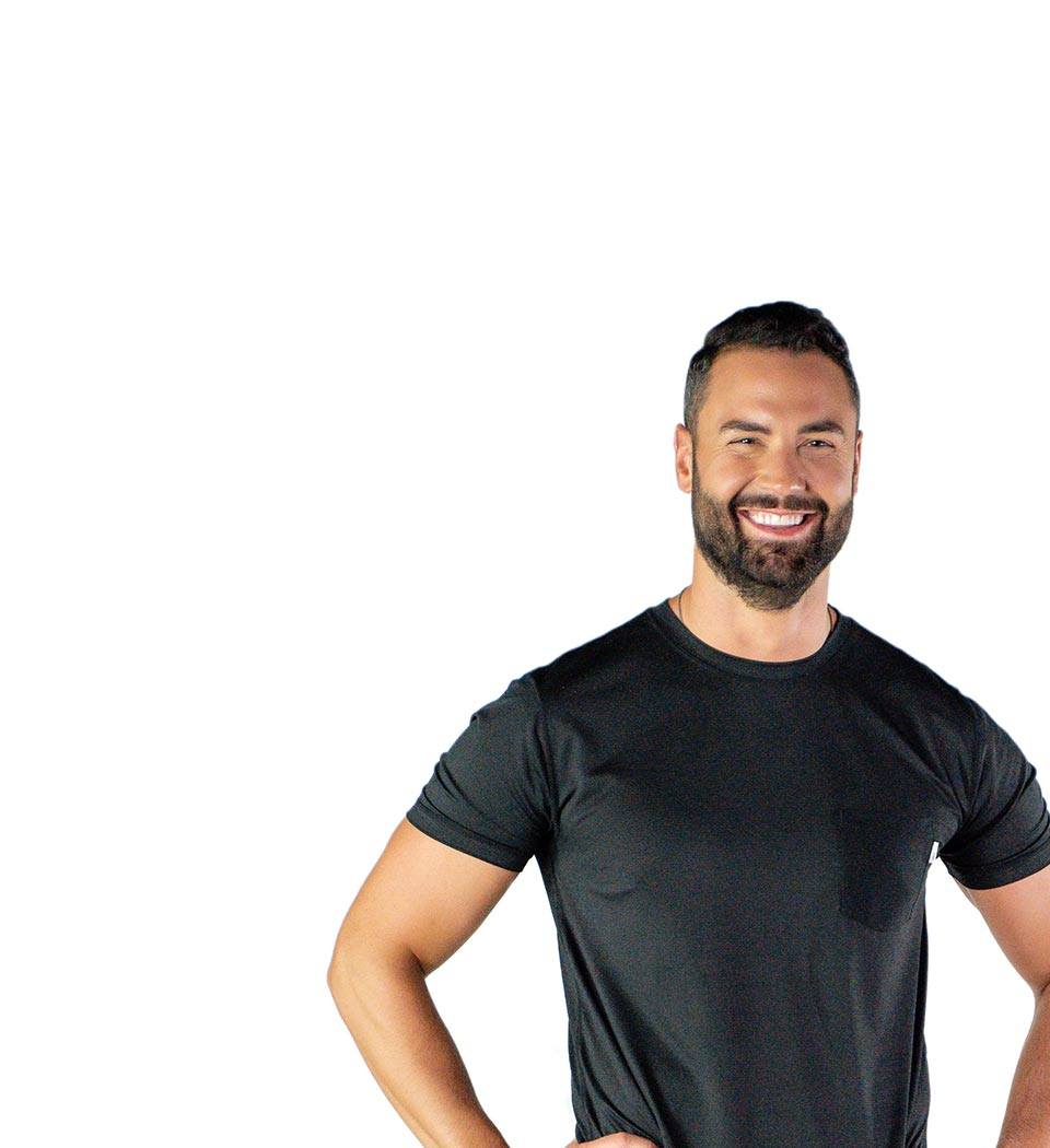 Barry’s instructor wearing a black top standing confidently smiling against a white background