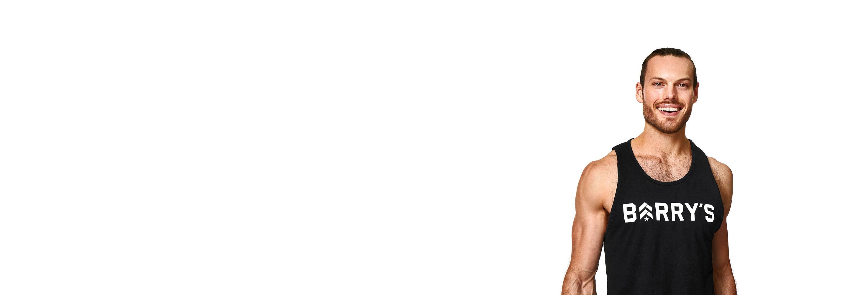 Barrys instruktör iklädd en svart topp står självsäkert och ler mot en vit bakgrund