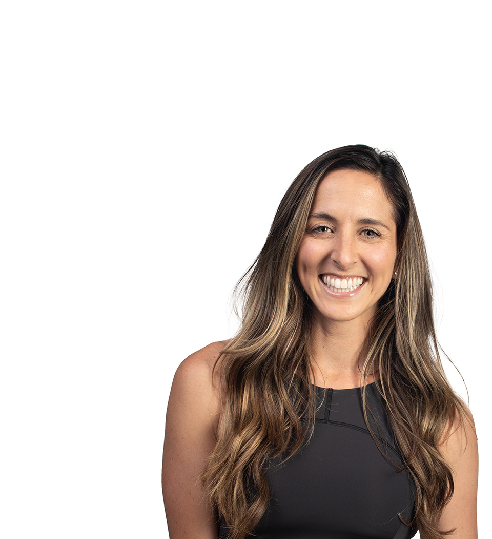 Barry’s instructor wearing a black top standing confidently smiling against a white background