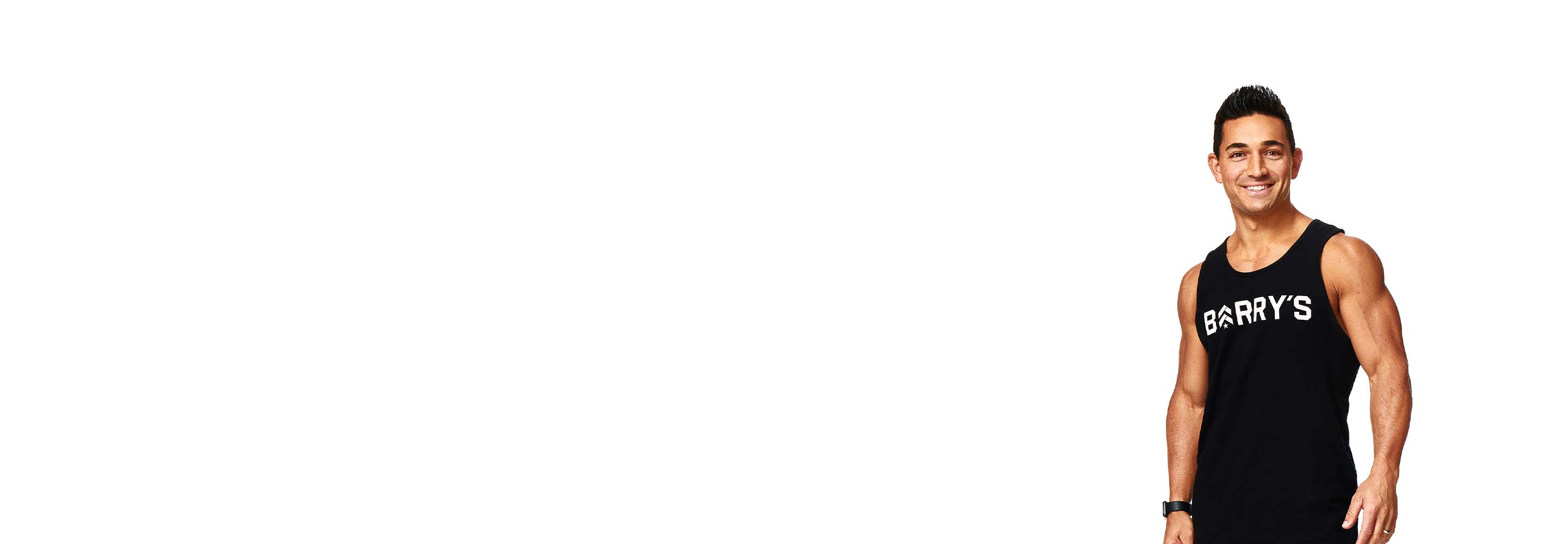 Barry’s instructor wearing a black top standing confidently smiling against a white background