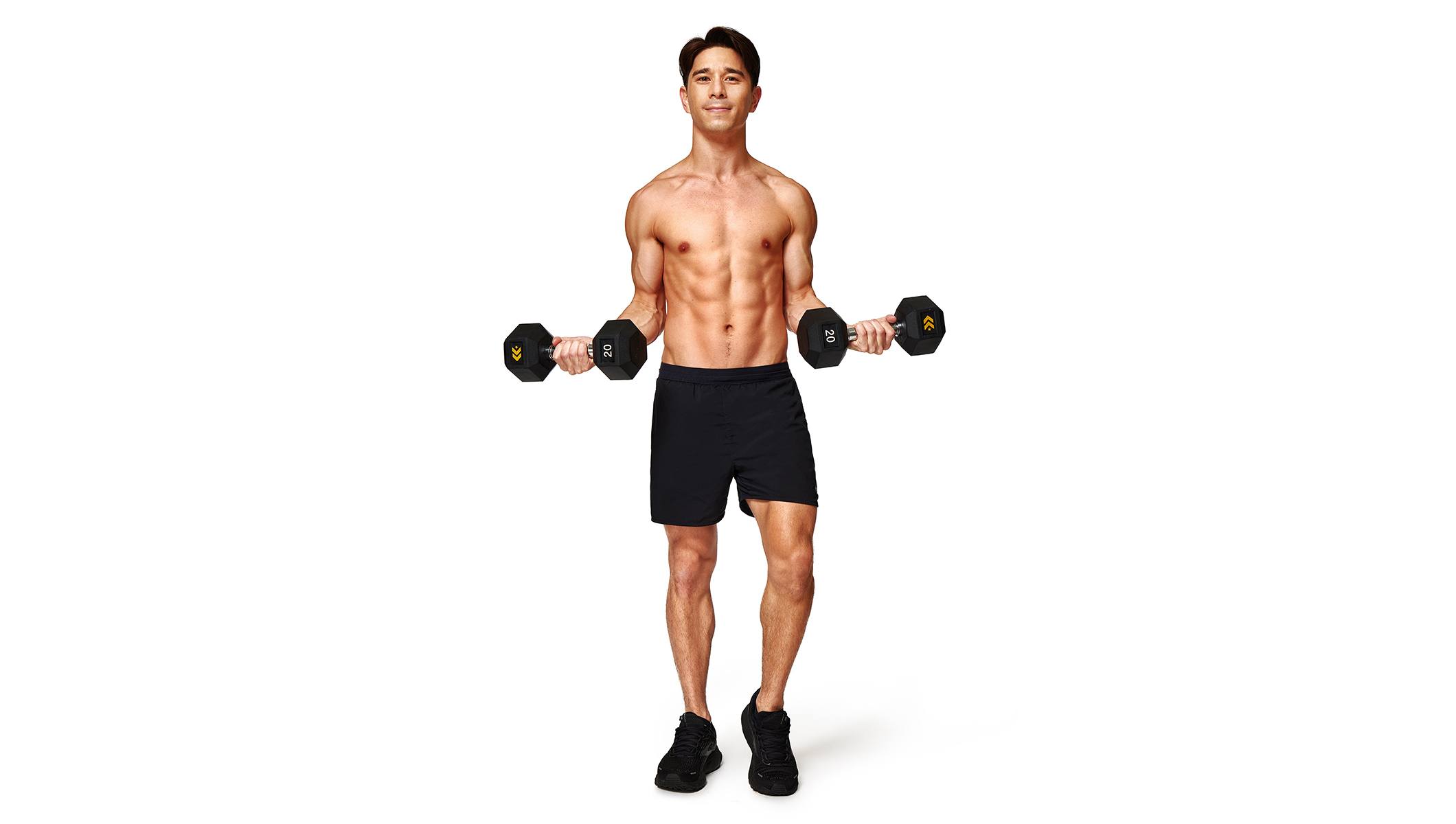 Barry’s instructor shirtless standing confidently holding weights out to the side smiling against a white background