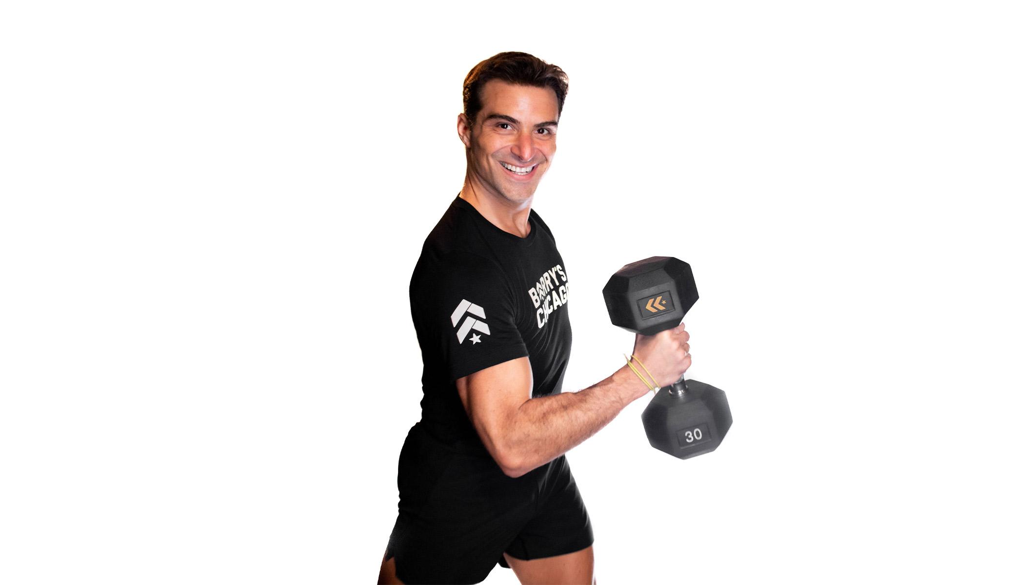 Barry's instructor standing confidently curling a weight wearing a black top against a white background.