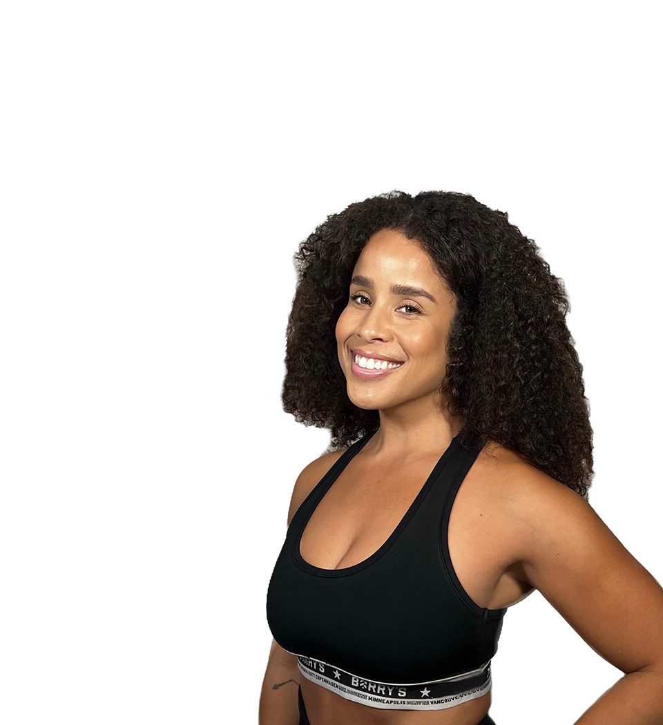 L'instructeur de Barry se tient debout avec confiance, vêtu d'un haut noir sur un fond blanc.