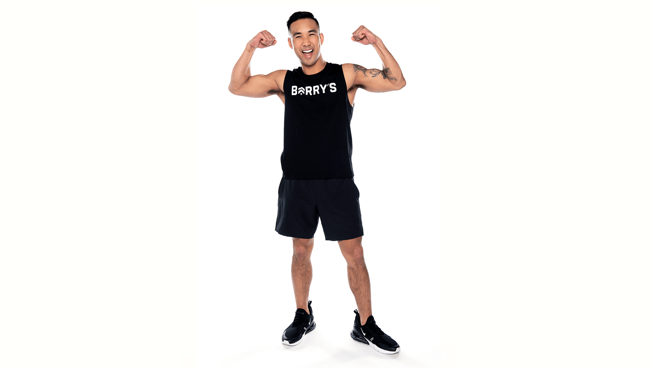 Barry's instructor standing confidently, wearing a black tank top against a white background, ready for the next workout challenge.