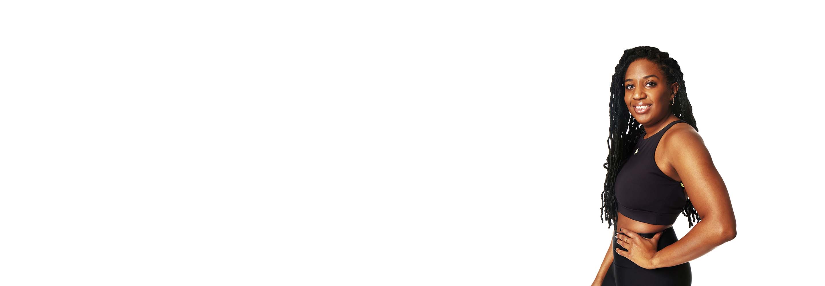 Barry’s instructor wearing a black top standing confidently smiling against a white background