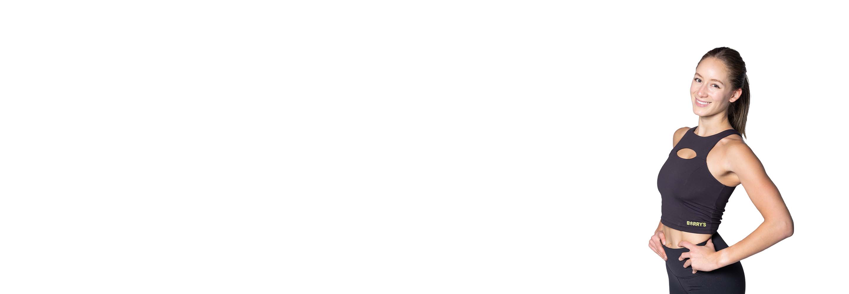 Barry’s instructor wearing a black top standing confidently smiling against a white background