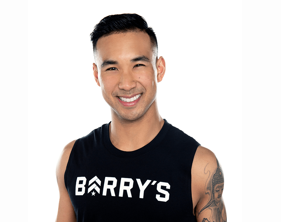 Barry's instructor standing confidently, wearing a black tank top against a white background, ready for the next workout challenge.