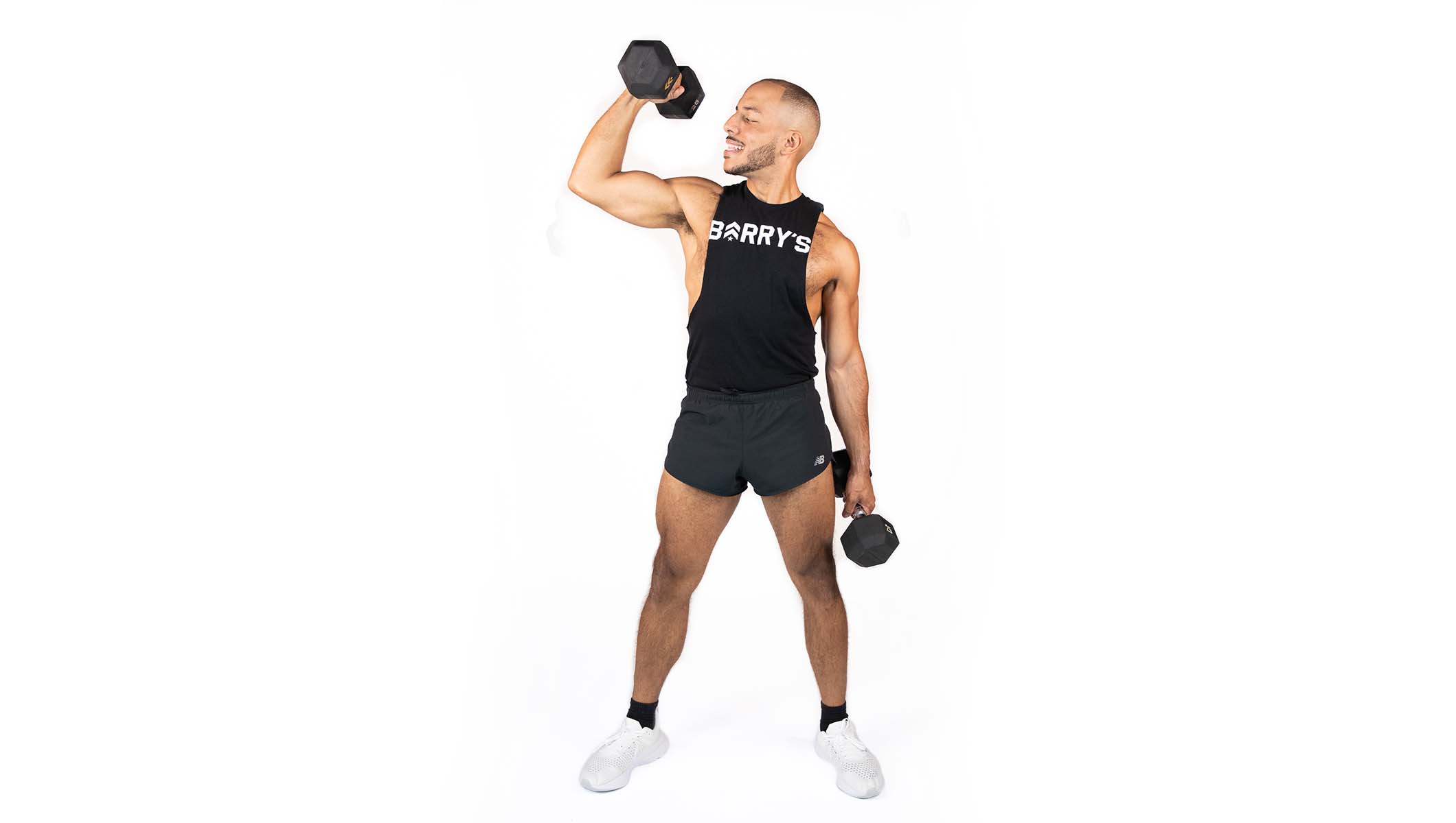 Barry's instructor lifting weights wearing a black top against a white background.
