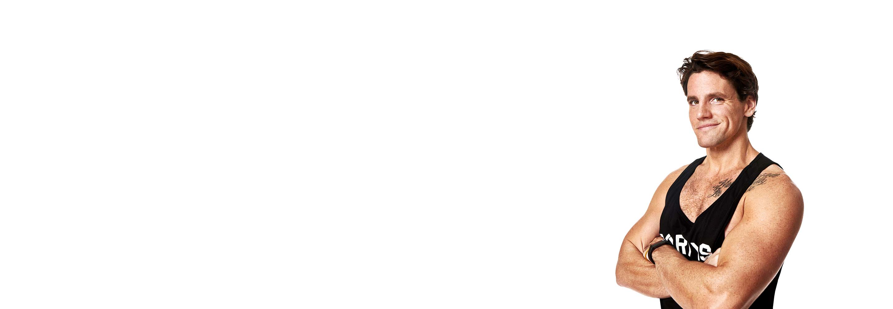 Barry’s instructor wearing a black top standing confidently smiling against a white background