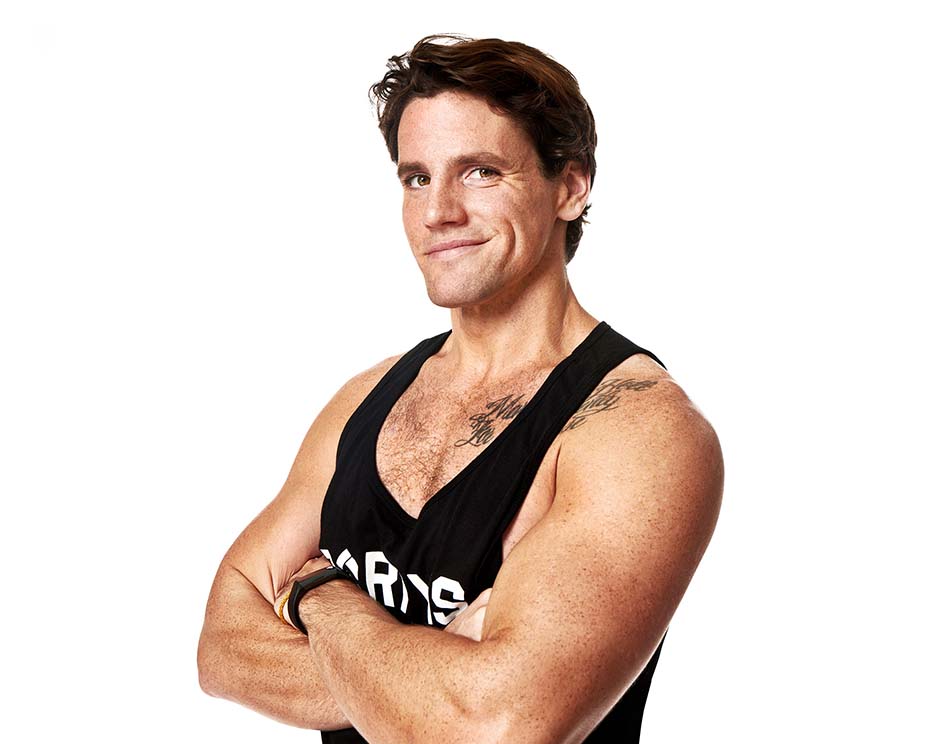 Barry’s instructor wearing a black top standing confidently smiling against a white background