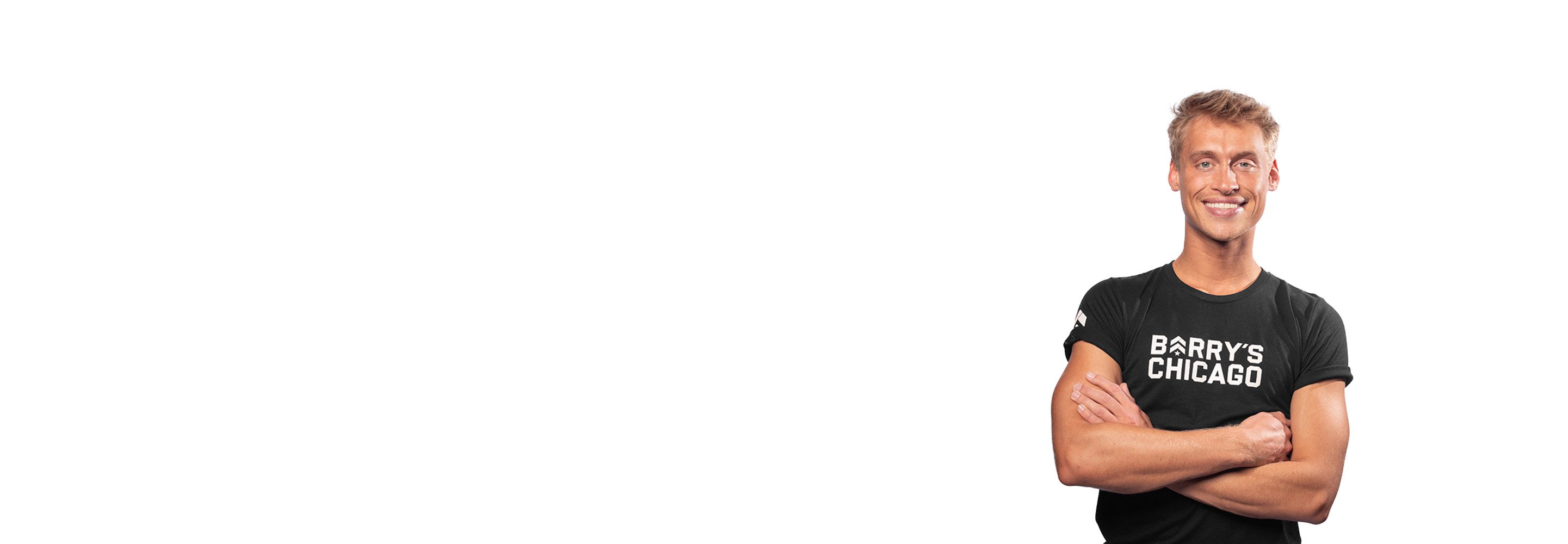 Barry’s instructor wearing a black top standing confidently smiling against a white background