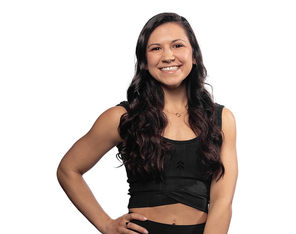 L'instructeur de Barry se tient debout avec confiance, vêtu d'un haut noir sur un fond blanc.