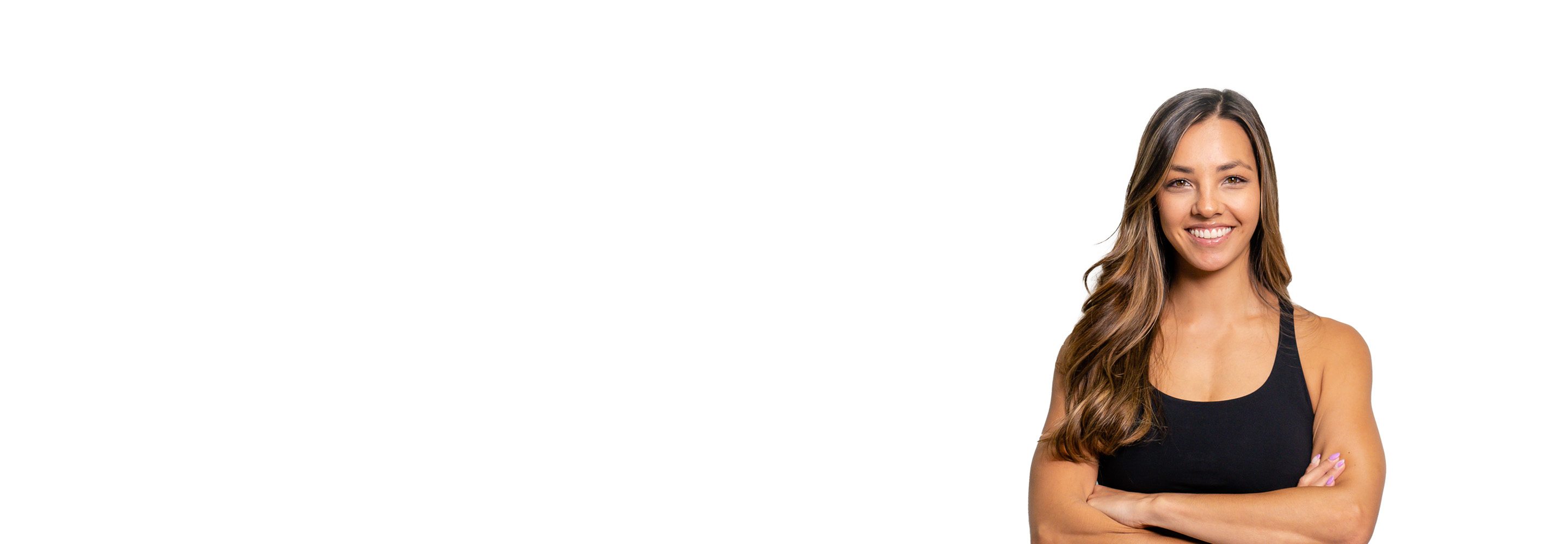 Barry’s instructor wearing a black top standing confidently smiling against a white background