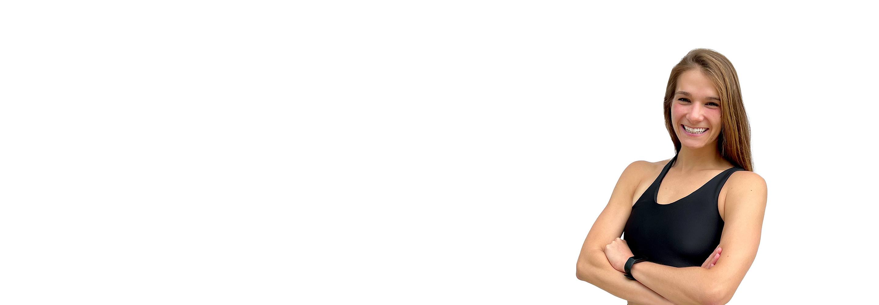 Barry’s instructor wearing a black top standing confidently smiling against a white background