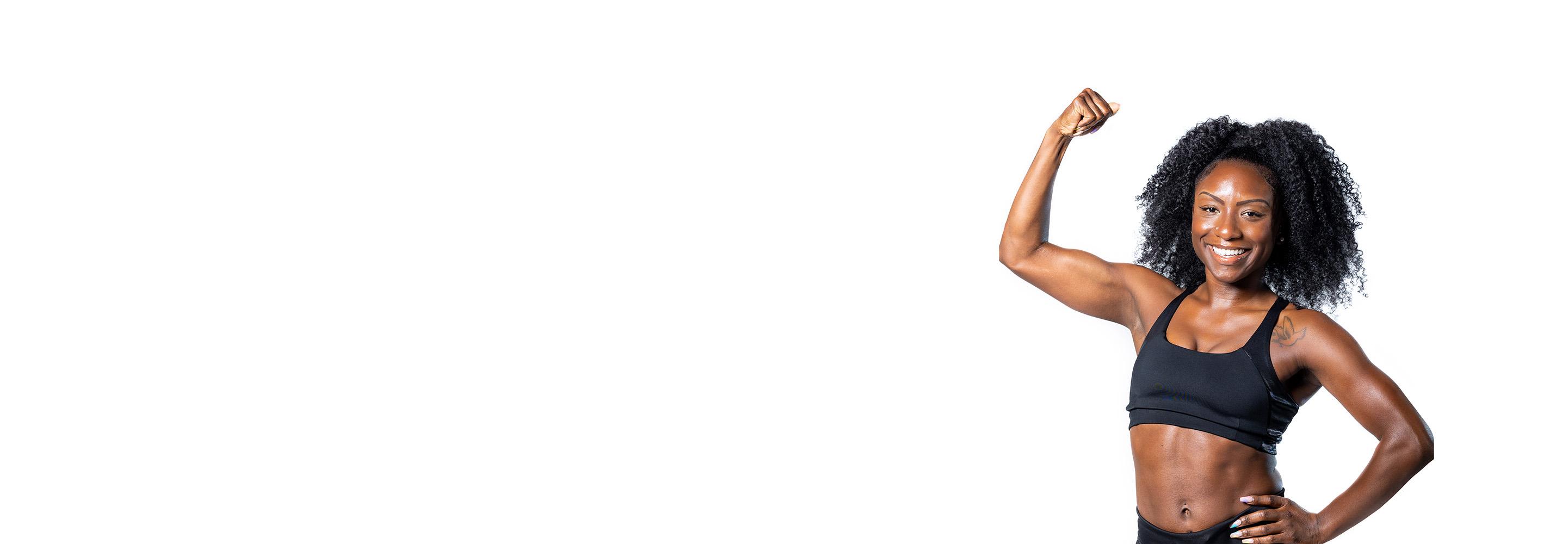 Barry’s instructor wearing a black top standing confidently smiling against a white background