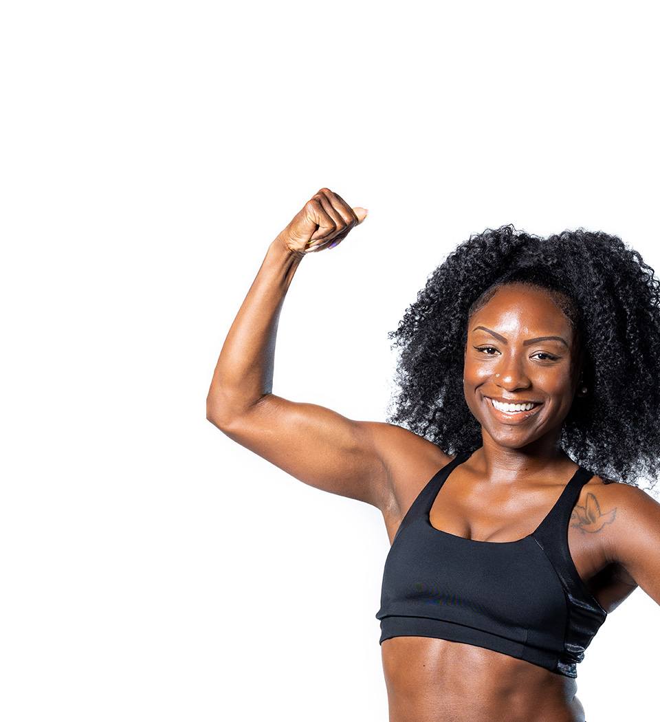 Barry’s instructor wearing a black top standing confidently smiling against a white background