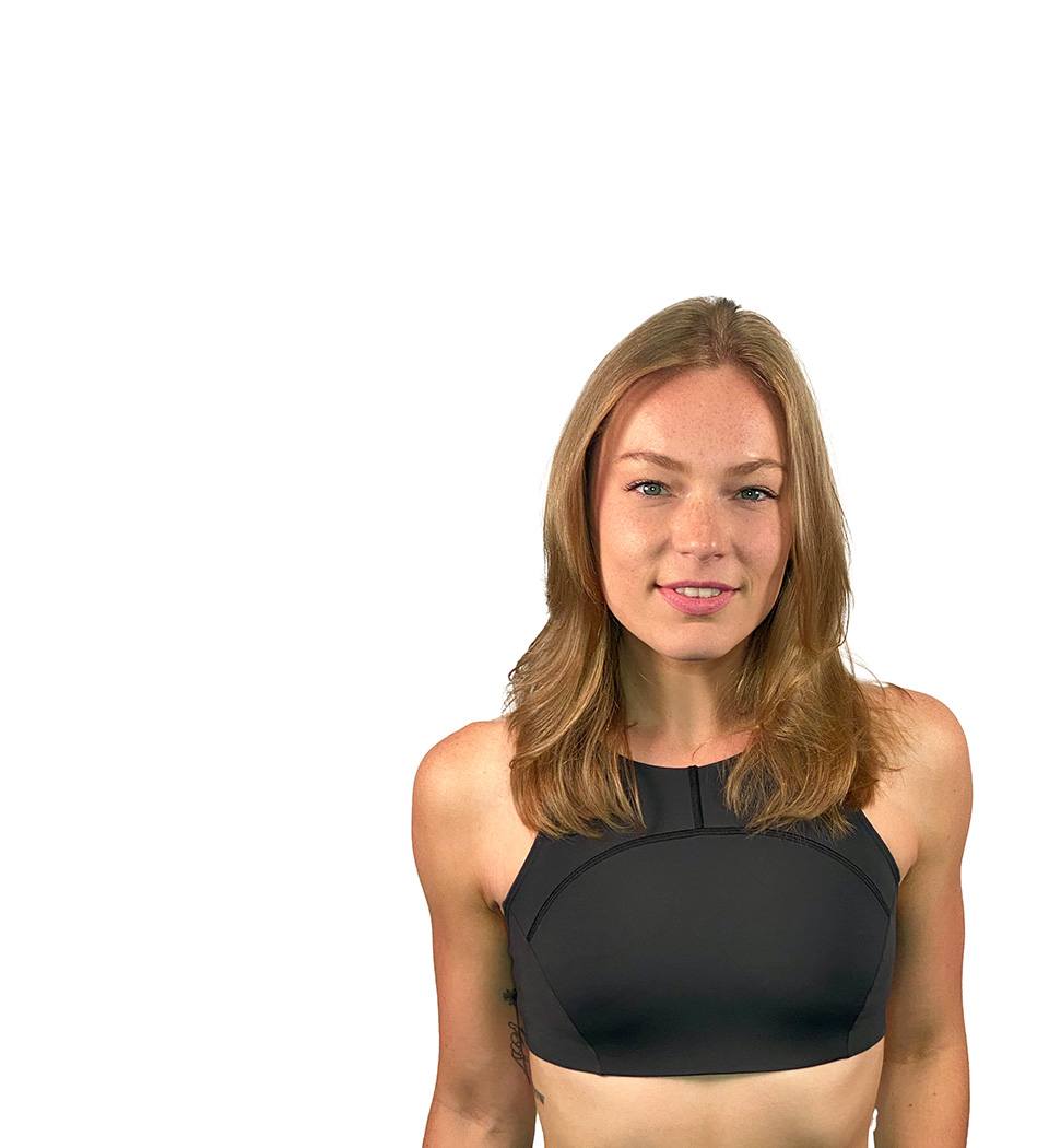 Barry’s instructor wearing a black top standing confidently smiling against a white background