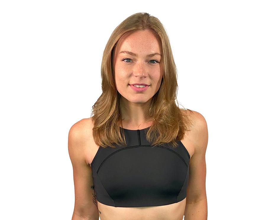 Barry’s instructor wearing a black top standing confidently smiling against a white background