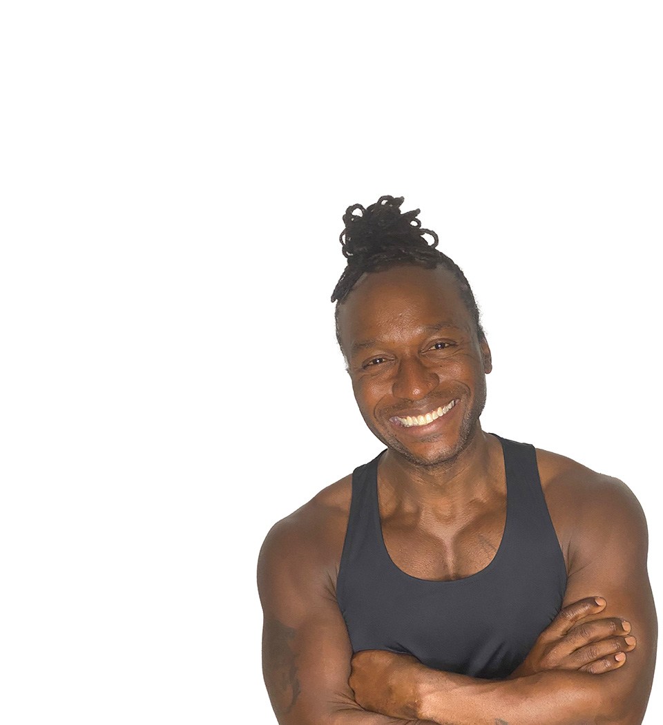 Barry’s instructor wearing a black top standing confidently smiling against a white background