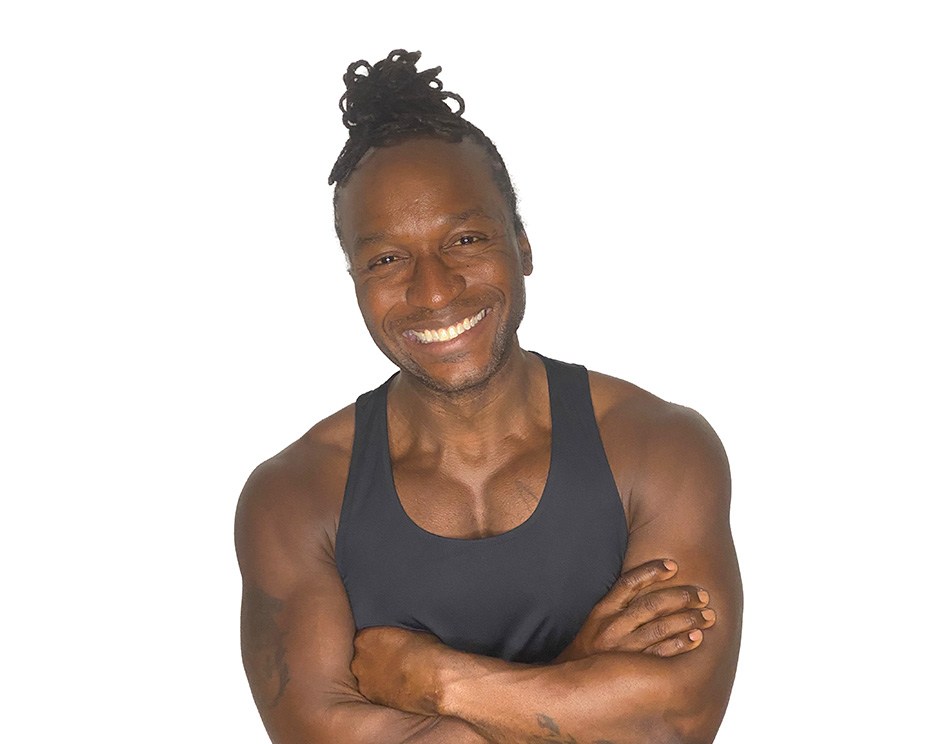 Barry’s instructor wearing a black top standing confidently smiling against a white background