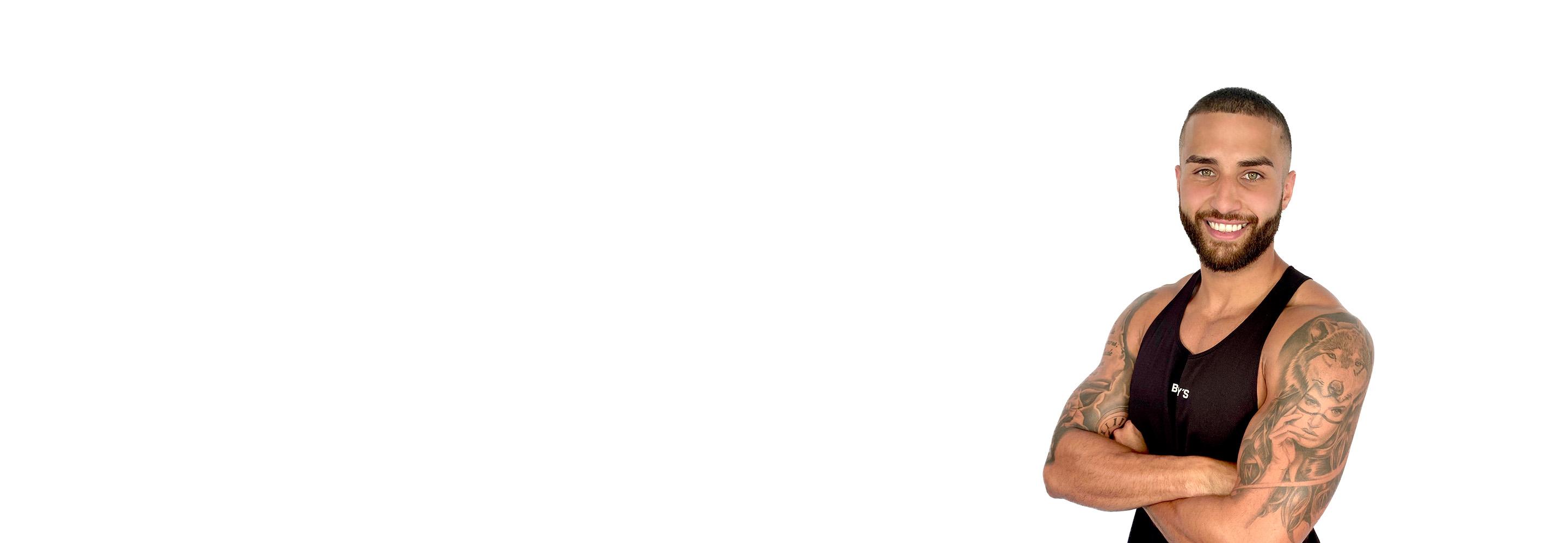 Barrys instruktör iklädd en svart topp står självsäkert och ler mot en vit bakgrund