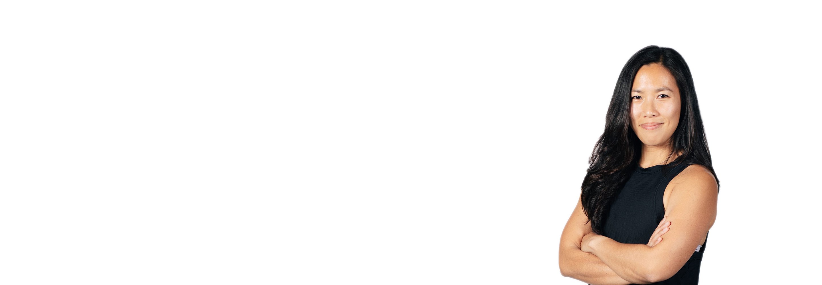 Barry's instructor standing confidently with arms crossed in front, wearing a black tank top against a white background, ready for the next workout challenge.