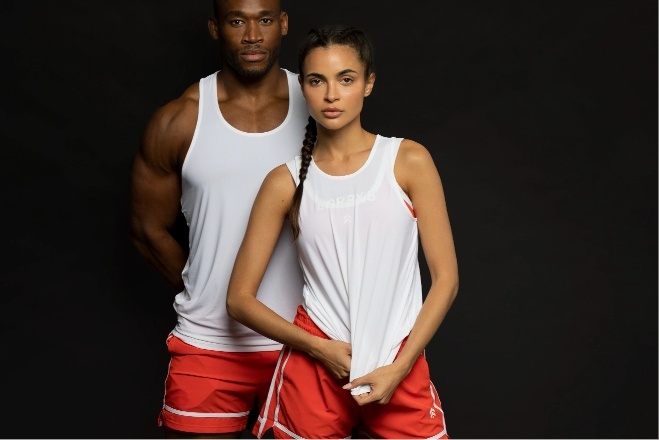Man and women modeling in Barry's white tanktop and red shorts