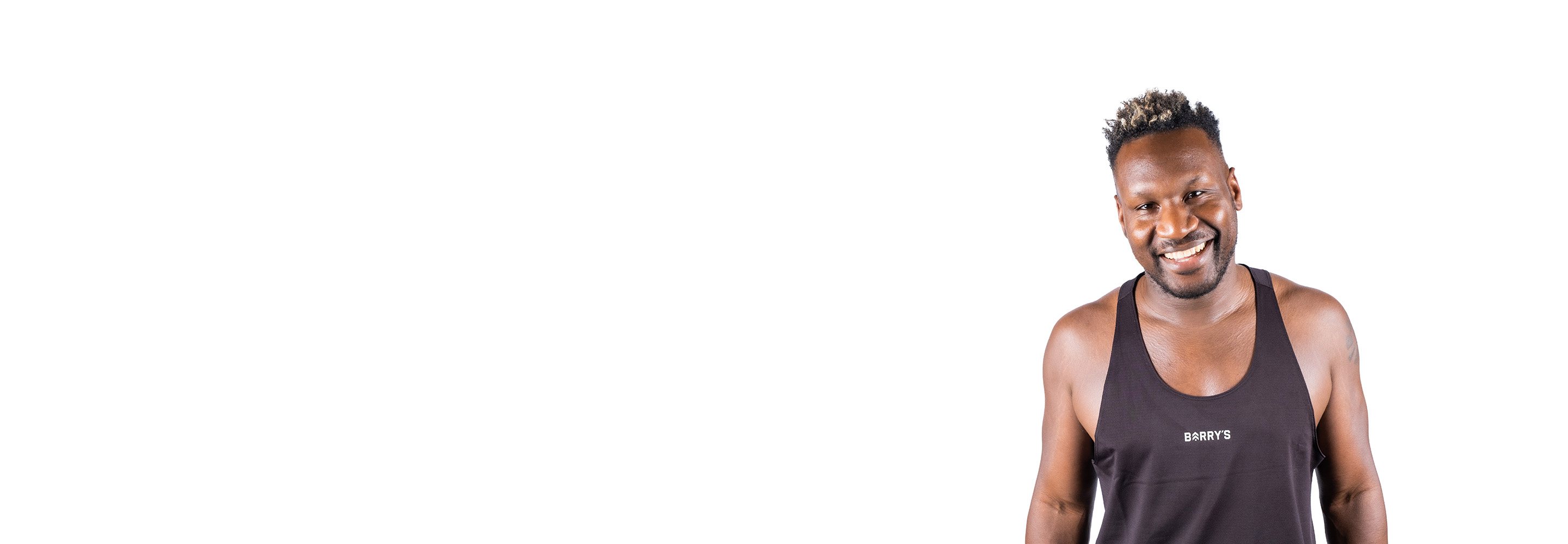 Barrys instruktör iklädd en svart topp står självsäkert och ler mot en vit bakgrund