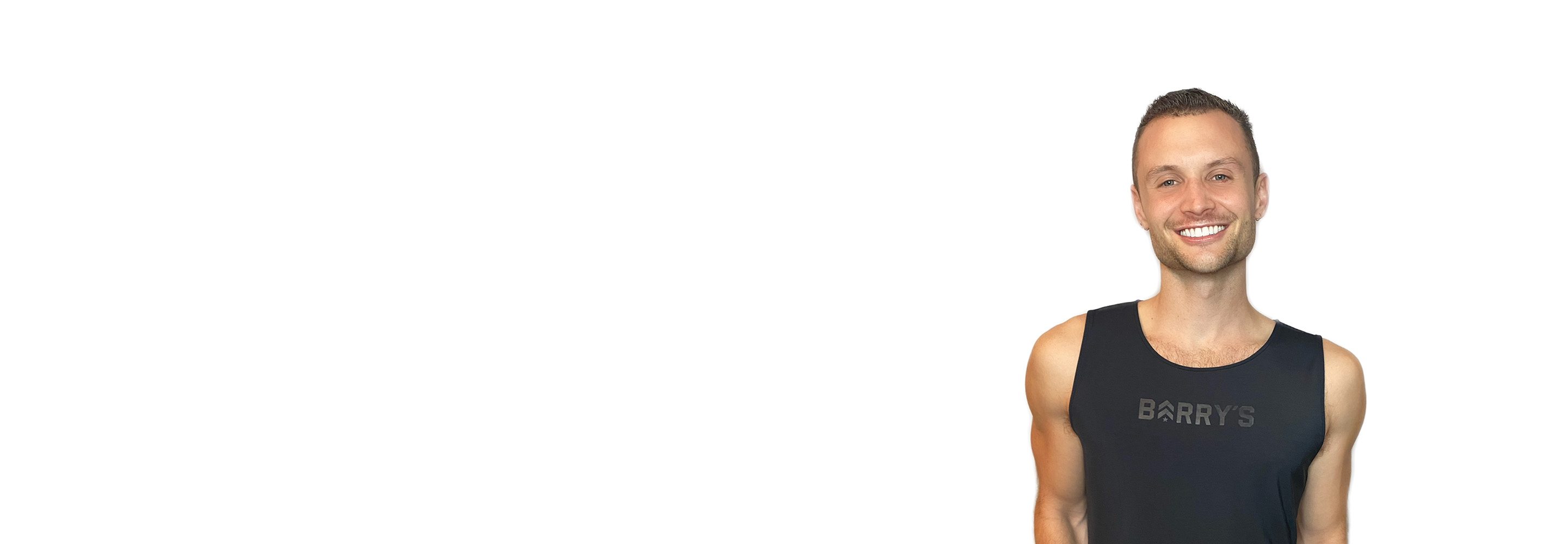 مدرب باري يرتدي قميصًا أسودًا ويقف بثقة مبتسمًا على خلفية بيضاء