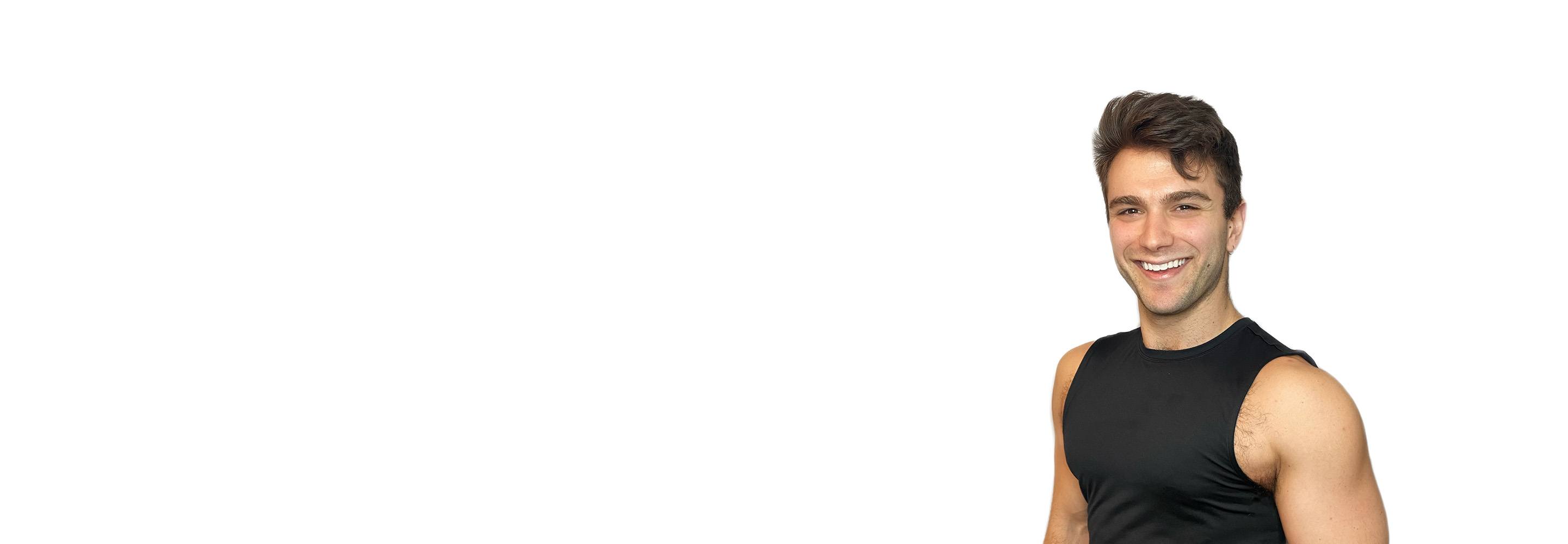 Barry’s instructor wearing a black top standing confidently smiling against a white background