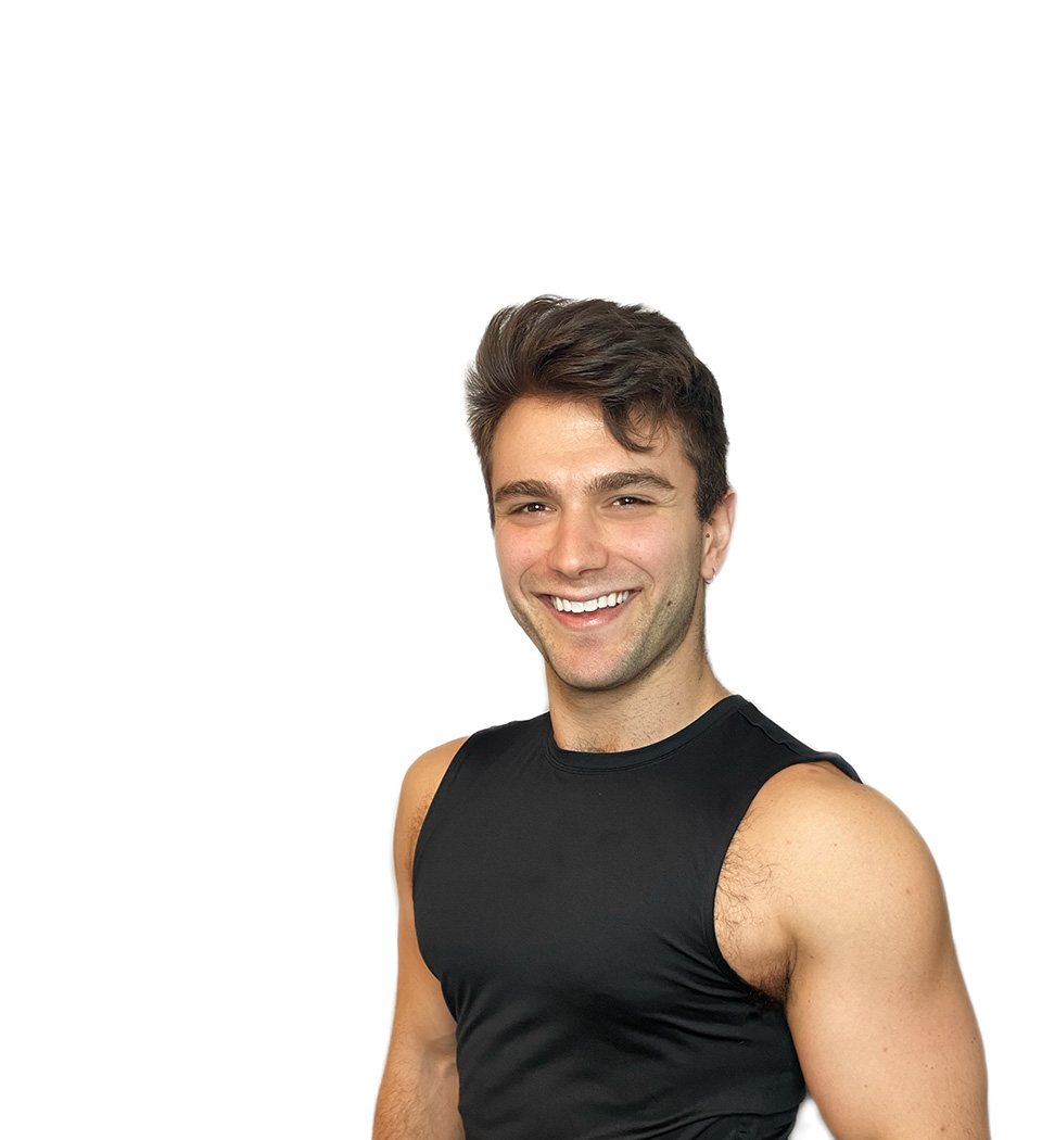 Barry’s instructor wearing a black top standing confidently smiling against a white background