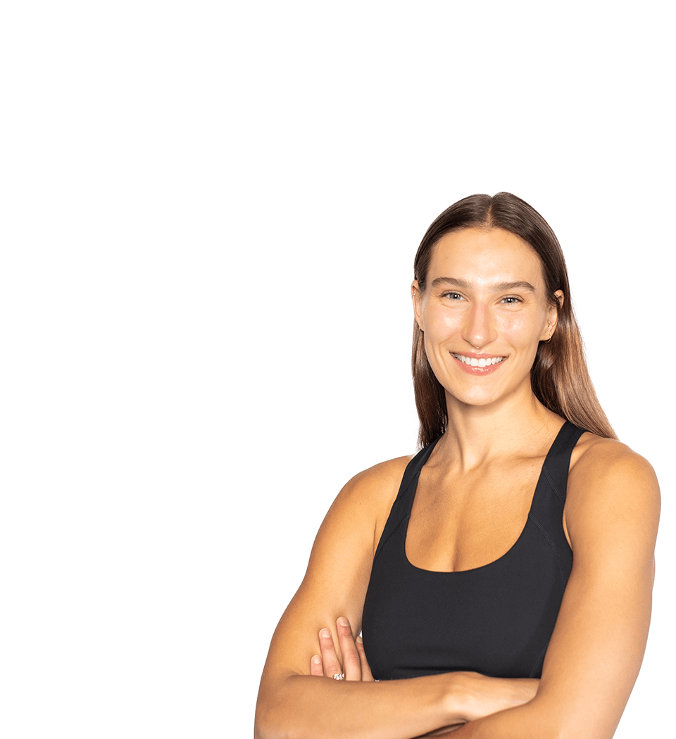 Barry’s instructor wearing a black top standing confidently smiling against a white background