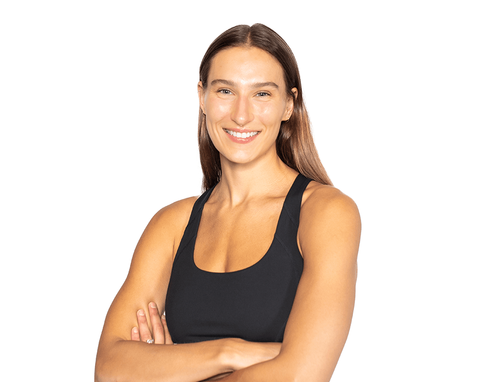 Barry’s instructor wearing a black top standing confidently smiling against a white background