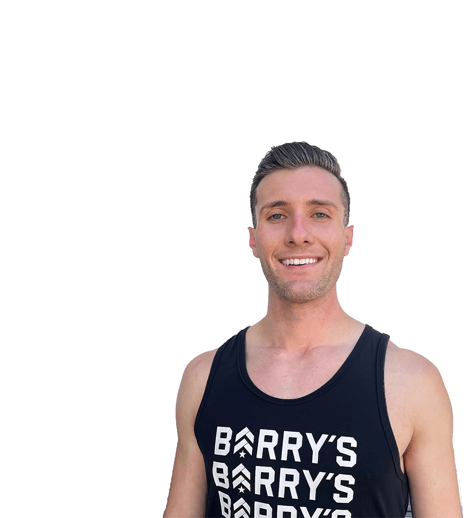 Barry's instructor standing confidently wearing a black tank top against a white background.