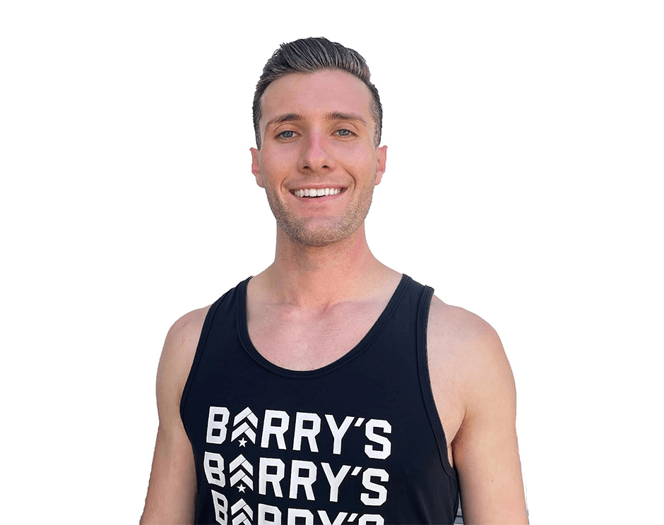 Barry's instructor standing confidently wearing a black tank top against a white background.