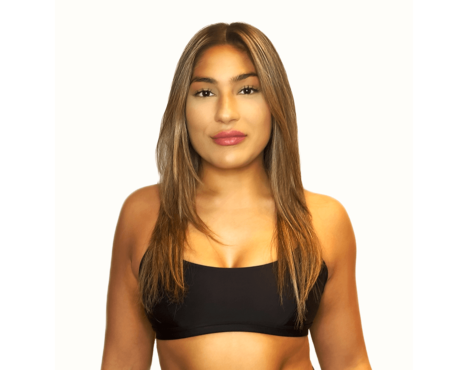 Barry’s instructor wearing a black top standing confidently smiling against a white background