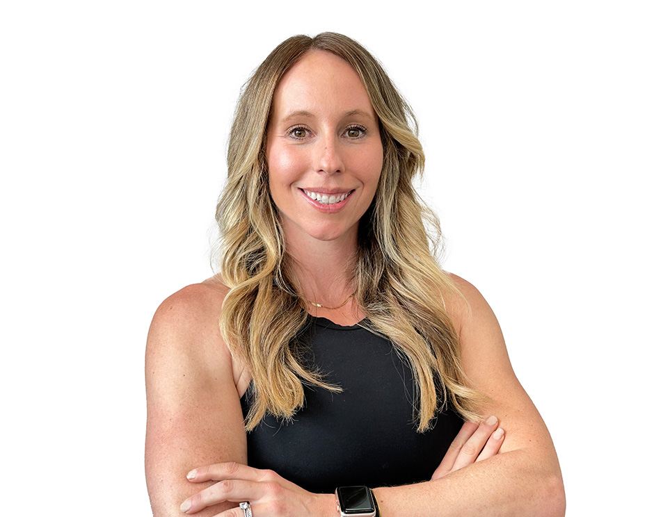 Barry’s instructor wearing a black top standing confidently smiling against a white background