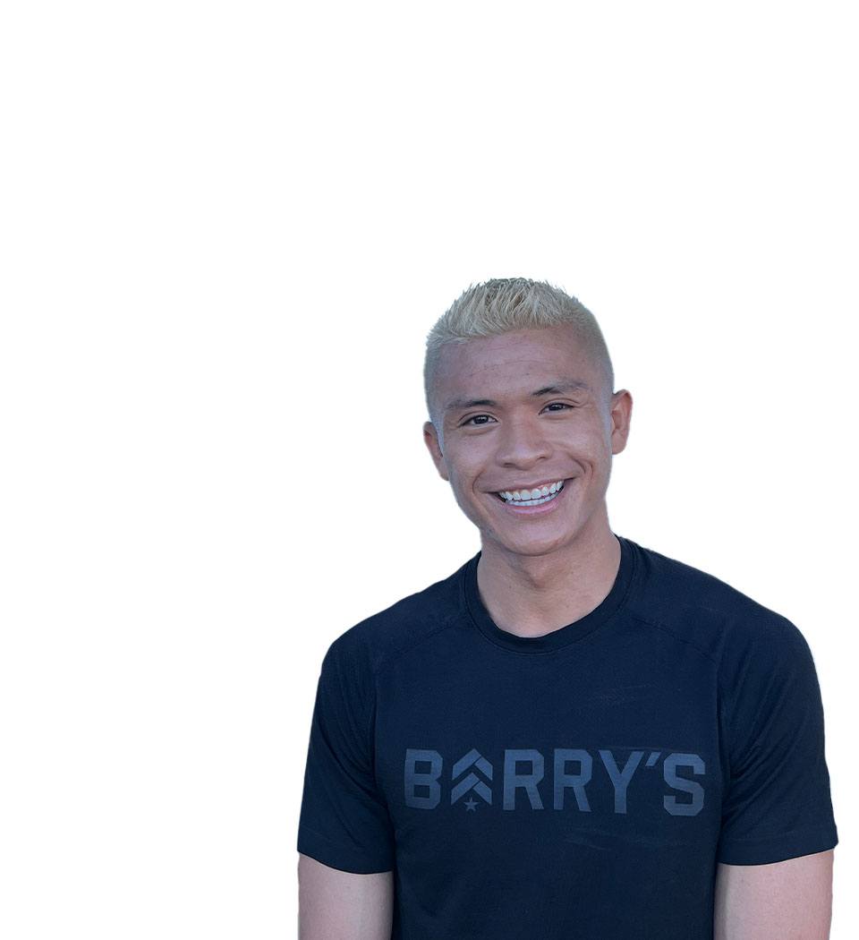 El instructor de Barry se mantiene firme, vistiendo una camiseta negra sobre un fondo blanco, listo para el próximo desafío de entrenamiento.