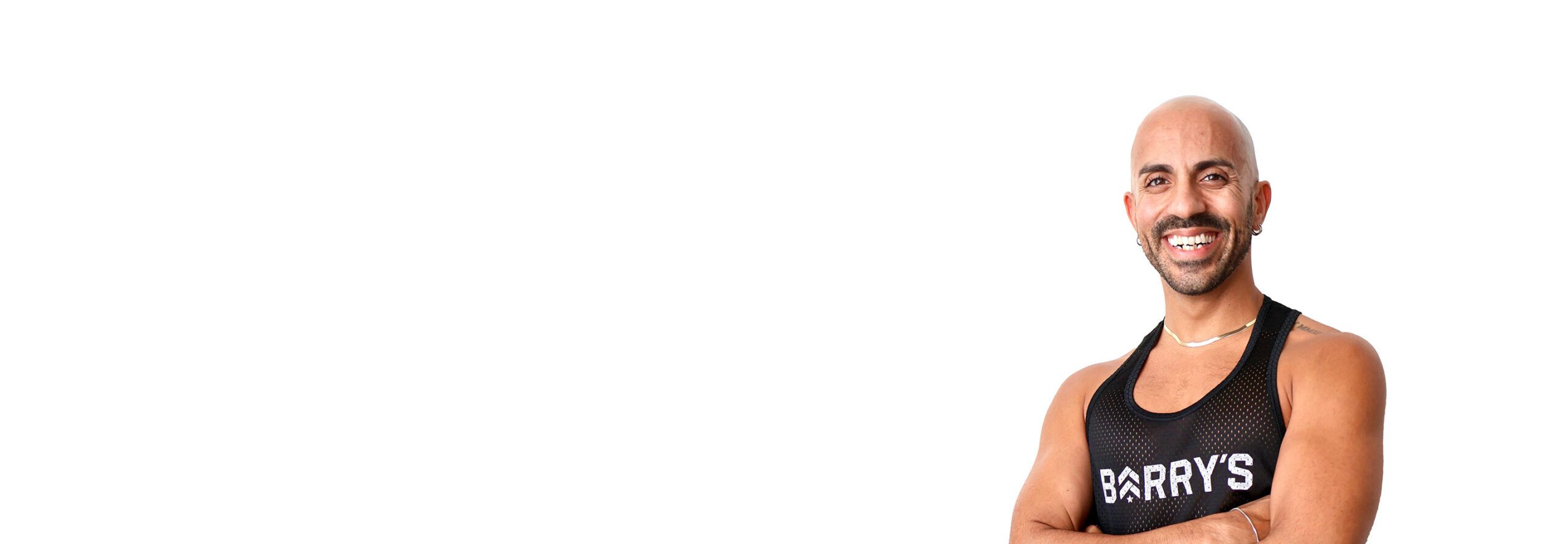 Barrys instruktör står självsäkert klädd i en svart topp mot en vit bakgrund.