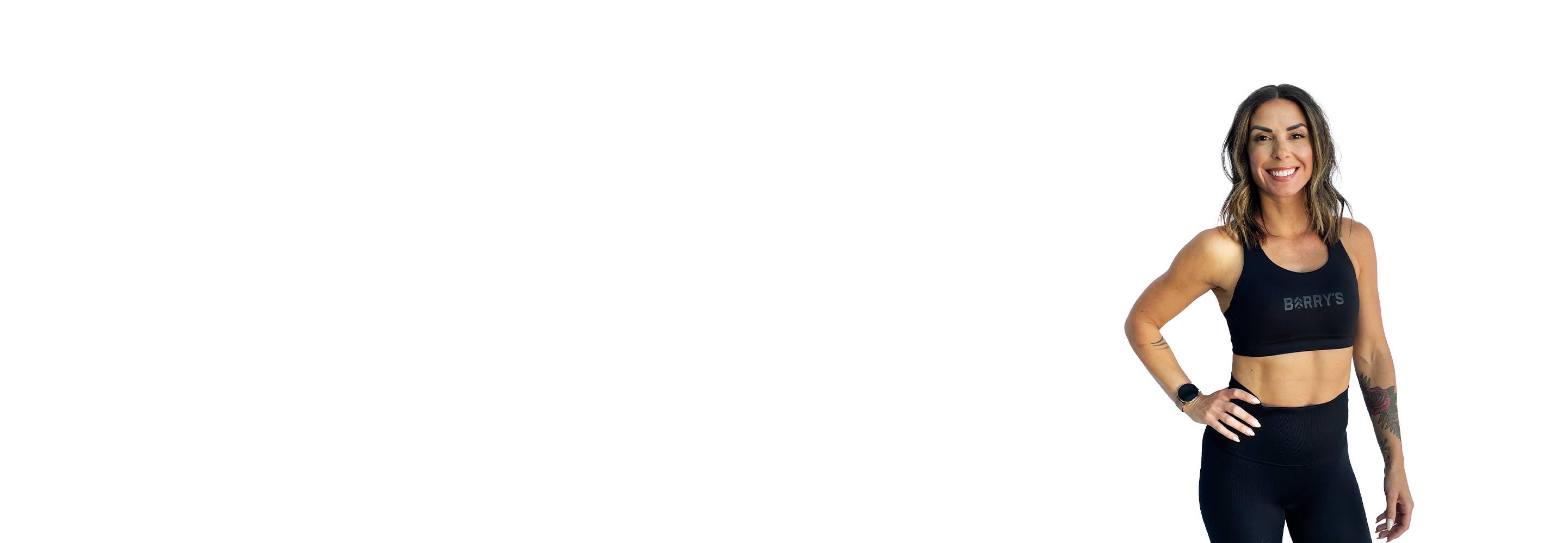 Barry’s instructor wearing a black top standing confidently smiling against a white background