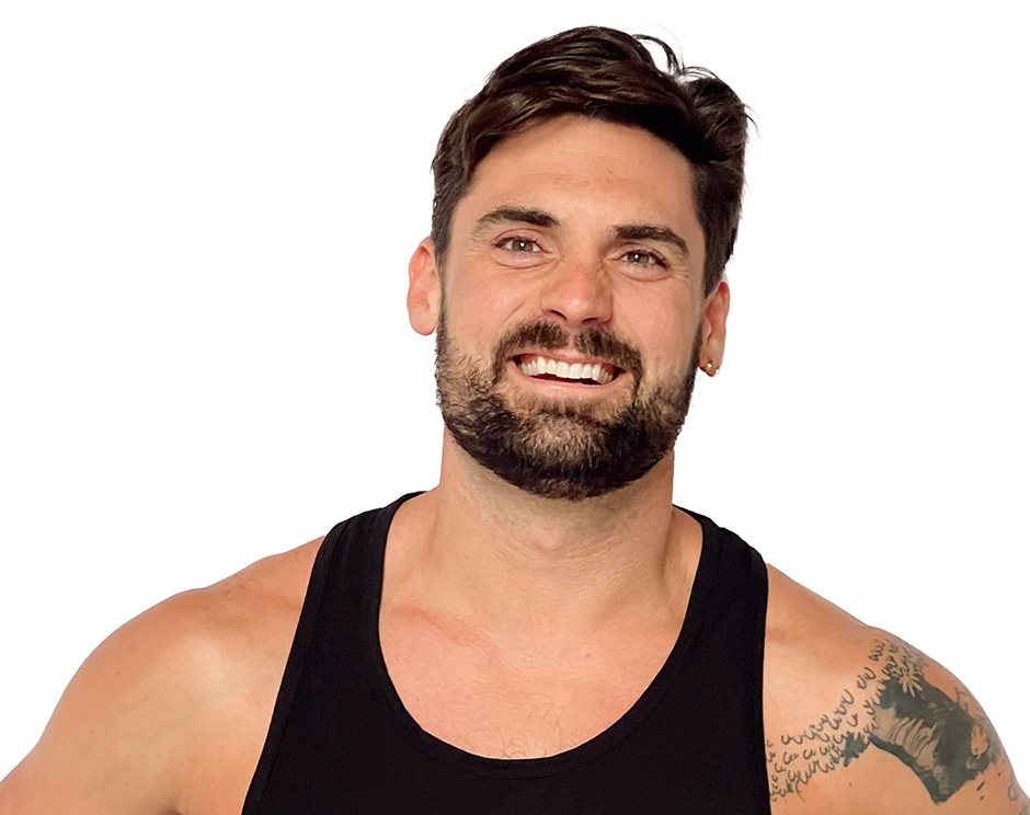 Barry’s instructor wearing a black top standing confidently smiling against a white background
