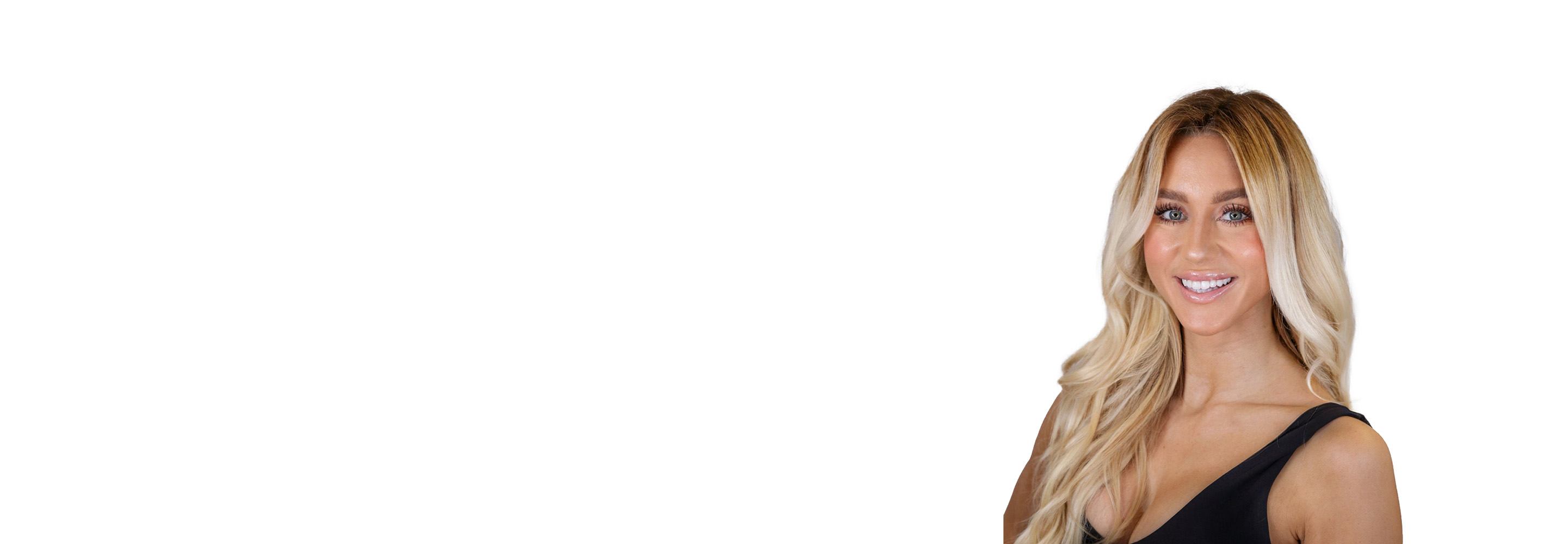 Barry’s instructor wearing a black top standing confidently smiling against a white background