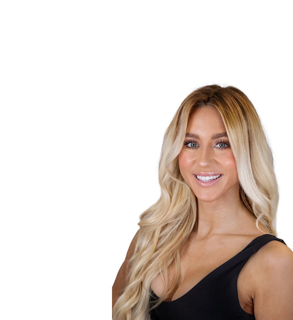 Barry’s instructor wearing a black top standing confidently smiling against a white background