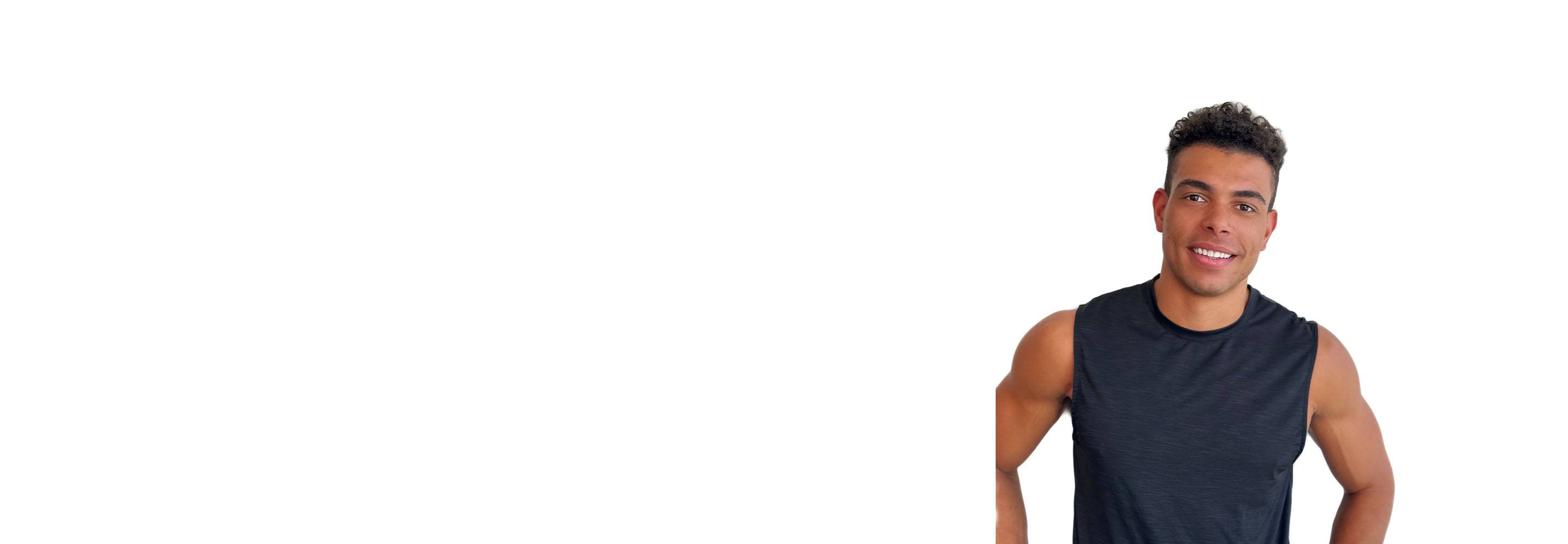 Barry’s instructor wearing a black top standing confidently smiling against a white background