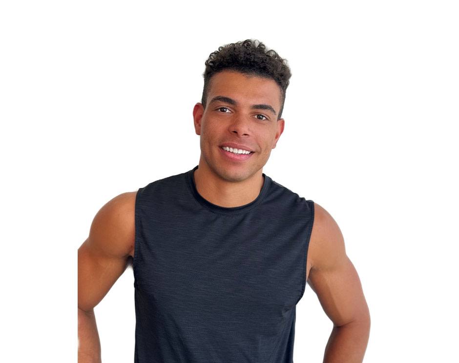 Barry’s instructor wearing a black top standing confidently smiling against a white background
