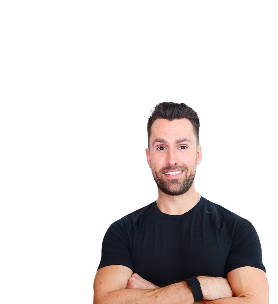 Barry’s instructor wearing a black top standing confidently smiling against a white background